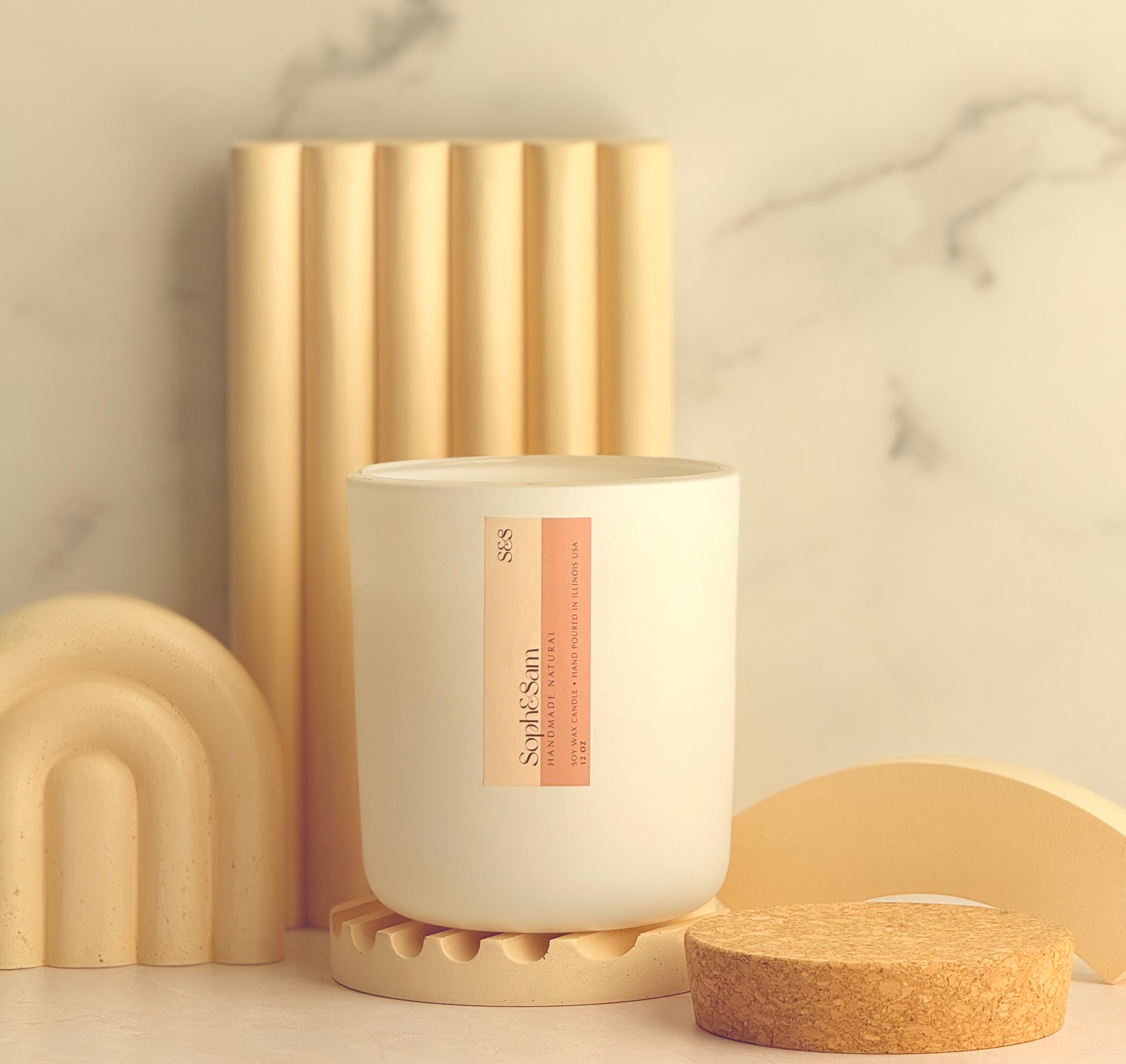 Natural soy wax candle resting on bath tray with minimal spa setup