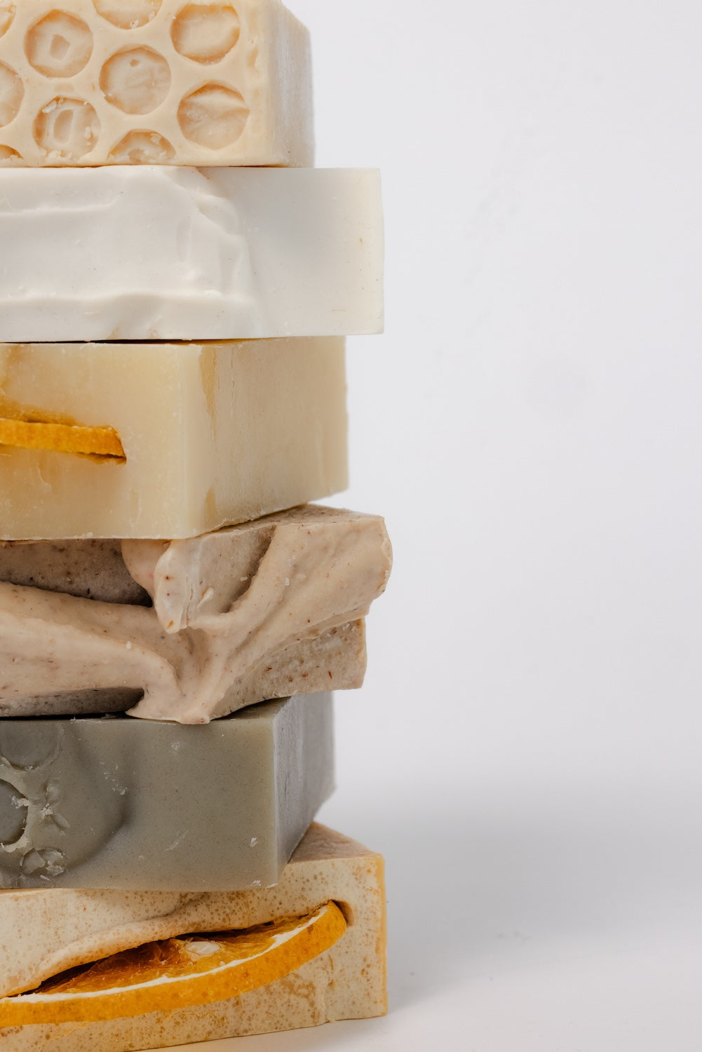 Stack of variously textured soap bars on a white background