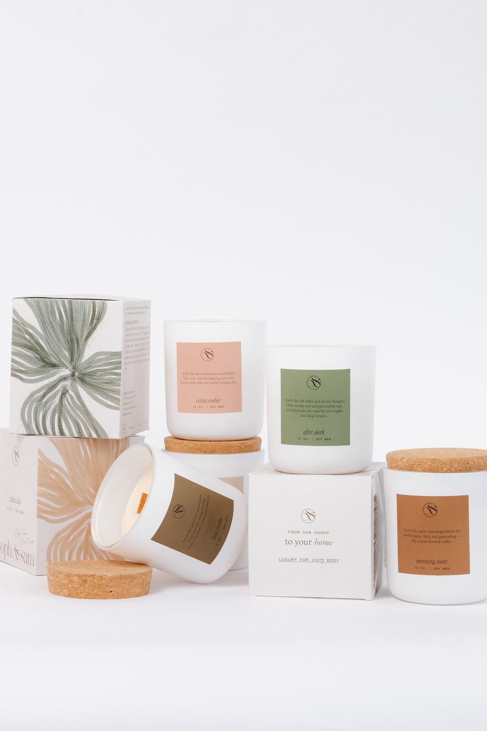 Collection of candles with various designs on lids against a white background